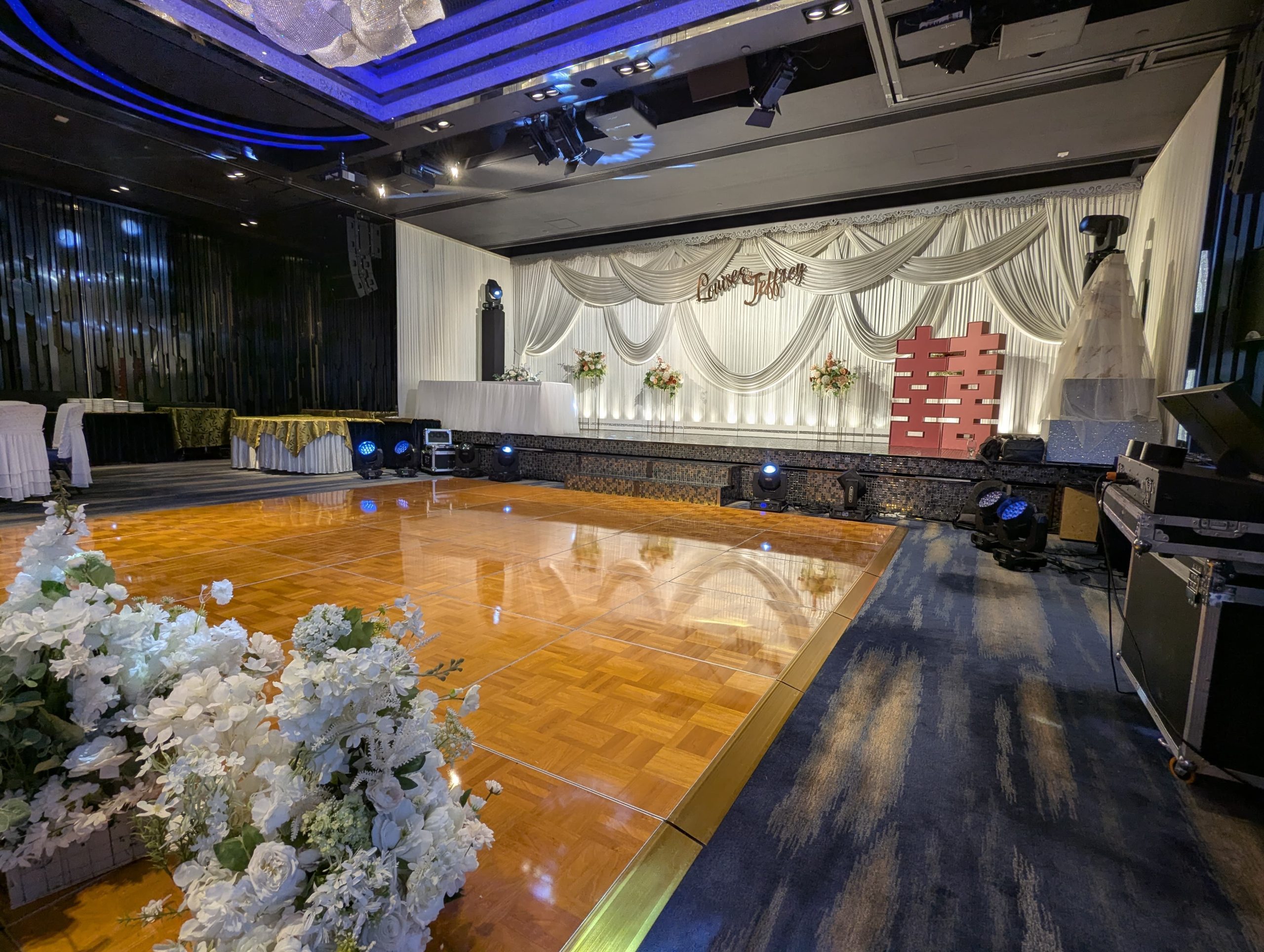 Polished parquet dance floor in a decorated banquet hall with a wedding stage