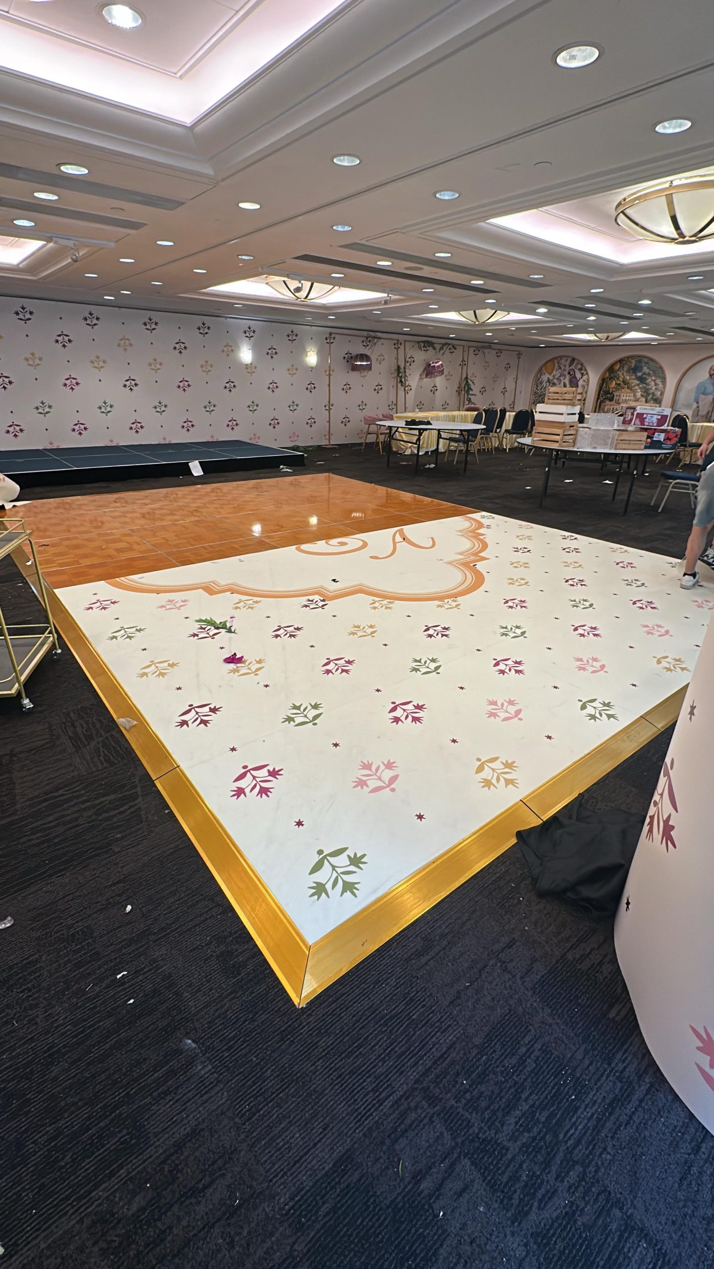 Custom rectangular dance floor with floral patterns and a gold-coloured border in a banquet hall