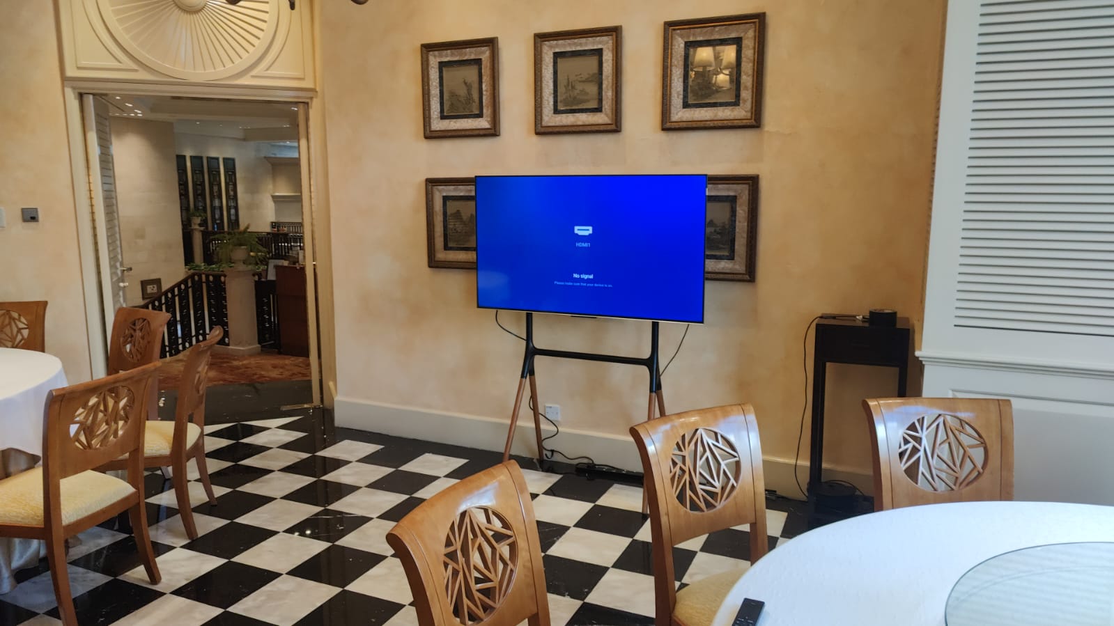 Large TV on a tripod stand in an elegant banquet room.