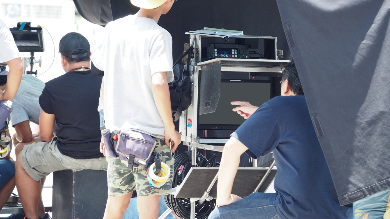 Production crew working around a rack of AV equipment and cables backstage
